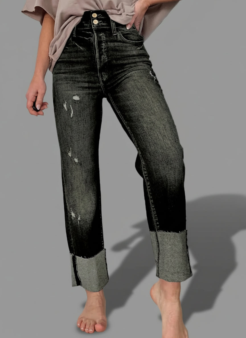 Person wearing black and gray distressed jeans.
