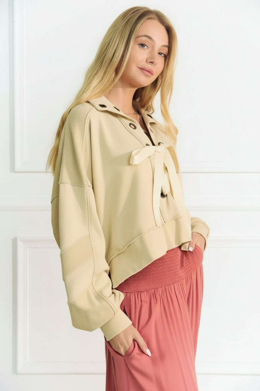 A lace-up exposed seam French terry top is a trendy and versatile garment that features a lace-up detail and visible seams.