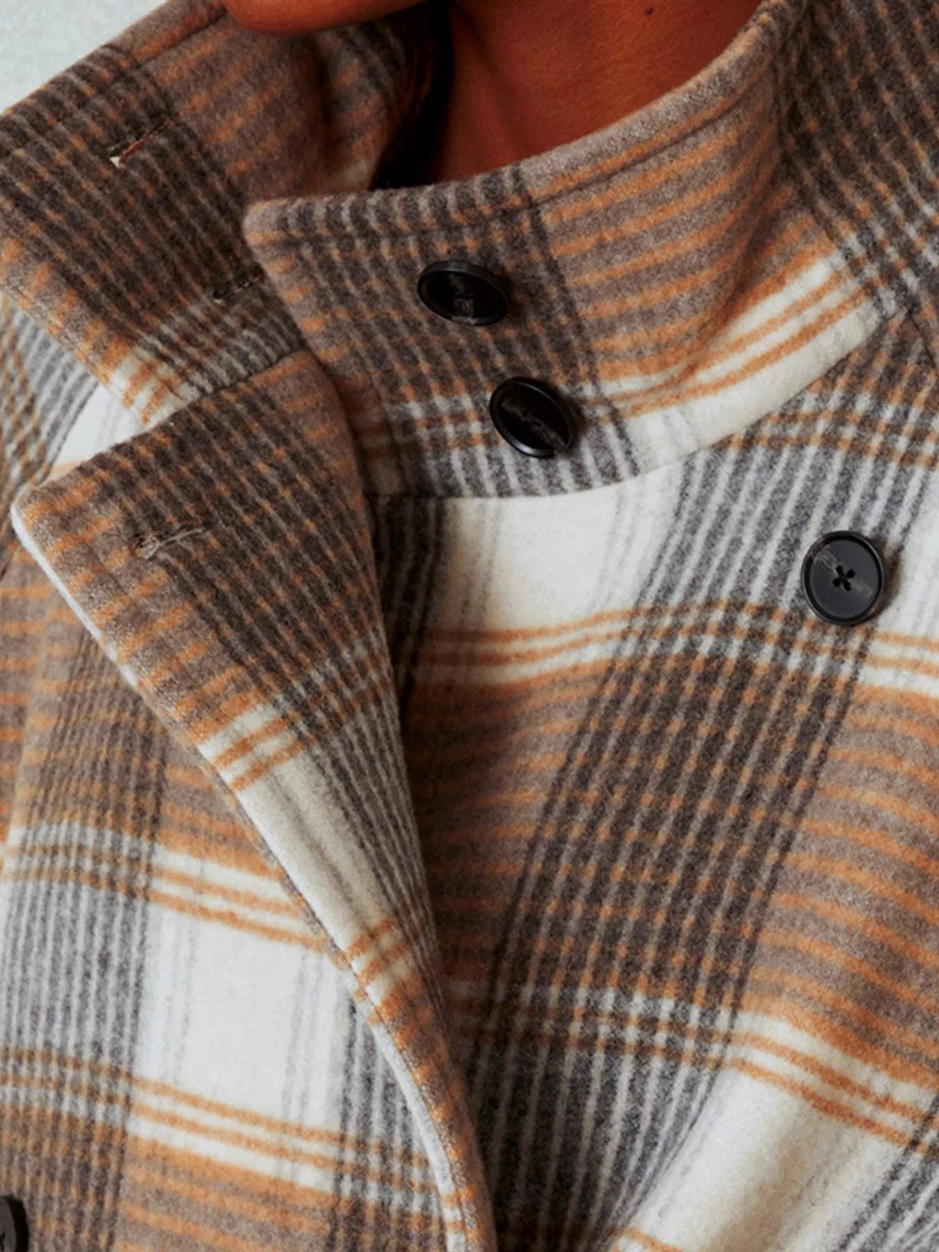 Close-up of a plaid coat with buttons
