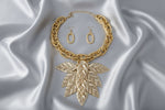 Women's Bib Necklace Set. Autumn-inspired Fall Seasonal Statement Necklace. Chunky Lightweight Gold Metal Twist Design Oval Double Link Chain Necklace Featuring Bib Comprised of High-Shine Polished Gold Acrylic Layered Filigree Leaf Drop Details. 