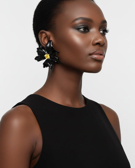 Women's Stud Earrings. Floral Statement Oversized Stud Earrings Featuring Large Dimensional Wavy Acrylic Petals in Bold Black with an Orange and Yellow Beaded Center. Bold and Eye-Catching Floral Playful Elegance. Earrings Measure 4.25 inches and 2.25 inches Tall. Post Backing.