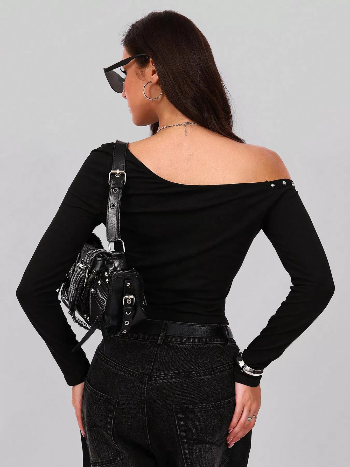  Black off-shoulder top and black pants with a black bag over her shoulder 