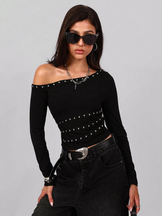 Woman wearing a black off-shoulder top with studs and black pants