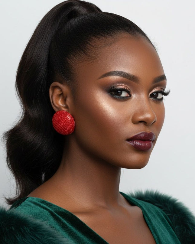 Women's Clip-On Earrings. Maximum Sparkle Statement Earrings. Bold Hollow Gold Metal Oversized Domed Clip-On Earrings Encrusted with Shimmering Red Rhinestones. Dome Measures .5 inches tall. Paddle Back Closure.