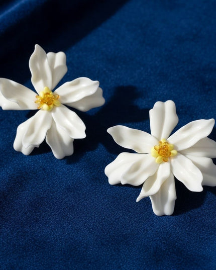 Women's Stud Earrings. Floral Statement Oversized Stud Earrings Featuring Large Dimensional Wavy Acrylic Petals in Dreamy Cream with an Orange and Yellow Beaded Center. Bold and Eye-Catching Floral Playful Elegance. Earrings Measure 4.25 inches and 2.25 inches Tall. Post Backing.