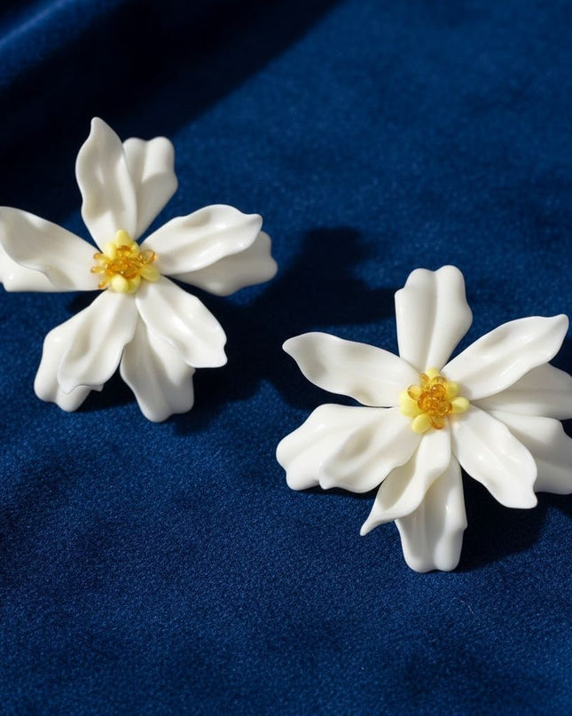 Women's Stud Earrings. Floral Statement Oversized Stud Earrings Featuring Large Dimensional Wavy Acrylic Petals in Dreamy Cream with an Orange and Yellow Beaded Center. Bold and Eye-Catching Floral Playful Elegance. Earrings Measure 4.25 inches and 2.25 inches Tall. Post Backing.