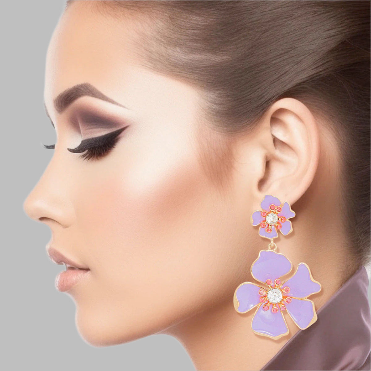 Women's Drop Earrings Gold Metal and Lavender Epoxy Tropical Flower Shaped Post Backing Earrings with Matching Larger Flower Drop Detail. Earrings Feature Rhinestone Center Detailing.