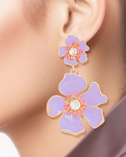 Women's Drop Earrings Gold Metal and Lavender Epoxy Tropical Flower Shaped Post Backing Earrings with Matching Larger Flower Drop Detail. Earrings Feature Rhinestone Center Detailing.