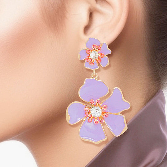 Women's Drop Earrings Gold Metal and Lavender Epoxy Tropical Flower Shaped Post Backing Earrings with Matching Larger Flower Drop Detail. Earrings Feature Rhinestone Center Detailing.