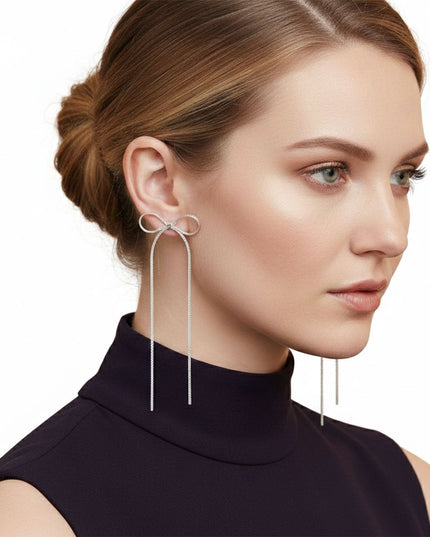 Women's Dangle Earrings. Simple Elegance Silver Metal Ribbon Bow Shaped Earrings Featuring Long Drop Detail. Post Backing.