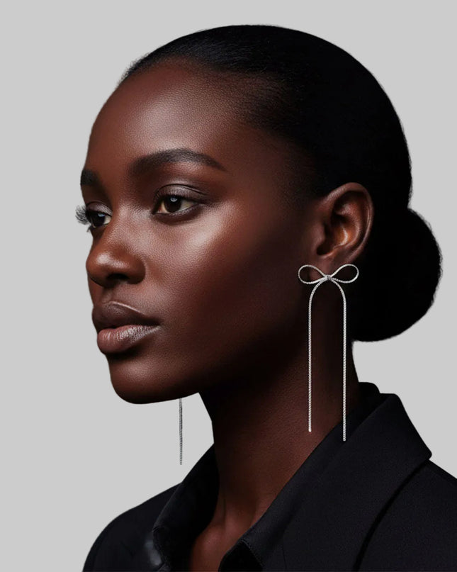 Women's Dangle Earrings. Simple Elegance Silver Metal Ribbon Bow Shaped Earrings Featuring Long Drop Detail. Post Backing.