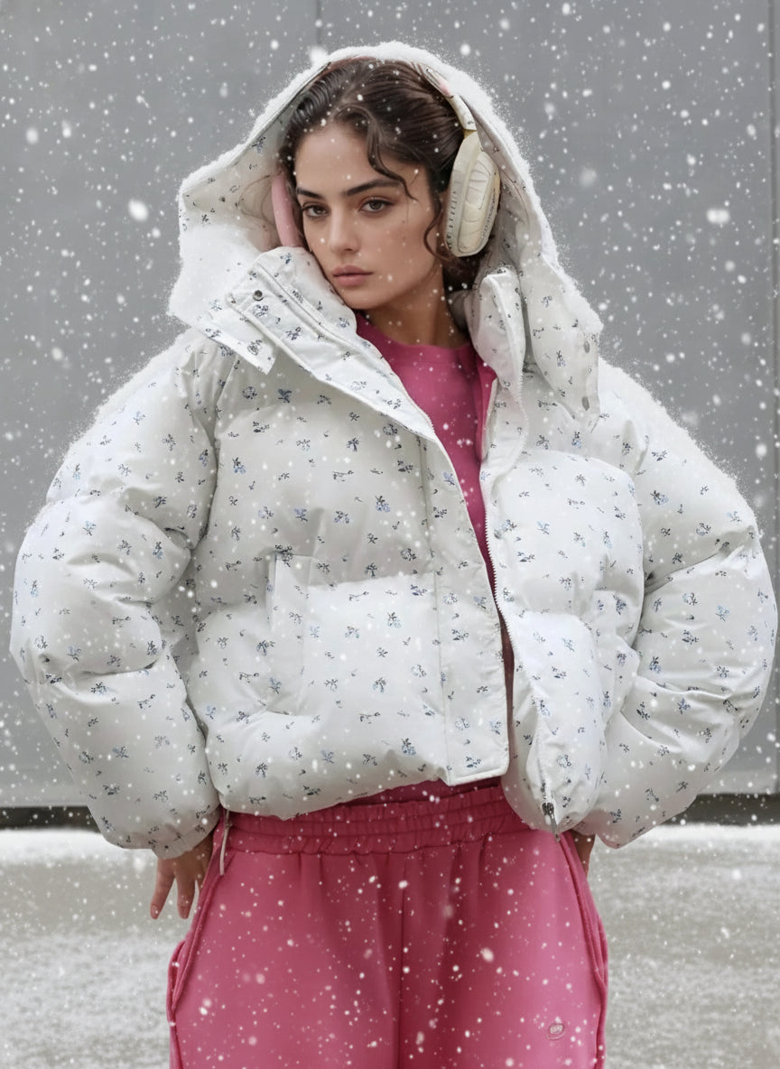 This oversized floral print puffer jacket combines fashion-forward design with superior winter protection. Crafted with premium down insulation and a water-resistant polyester shell, it features an all-over delicate floral pattern that adds feminine charm to cold-weather styling. The detachable hood with adjustable drawstrings provides customizable coverage, while the cropped silhouette offers a modern, fashion look. Ribbed cuffs and hem, making it perfect for urban adventures and casual outings. 