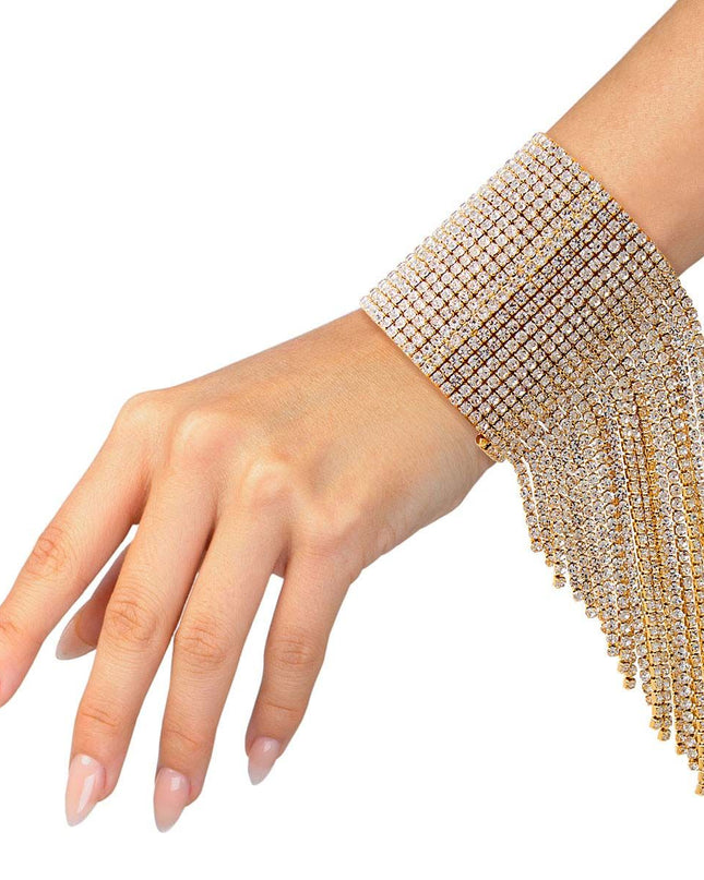 A bold gold cuff featuring twenty sleek fringe lines that drape with fluid, eye‑catching movement. Crafted from polished metal in a radiant gold finish, this adjustable statement piece delivers high‑impact shine with a modern, geometric edge. 