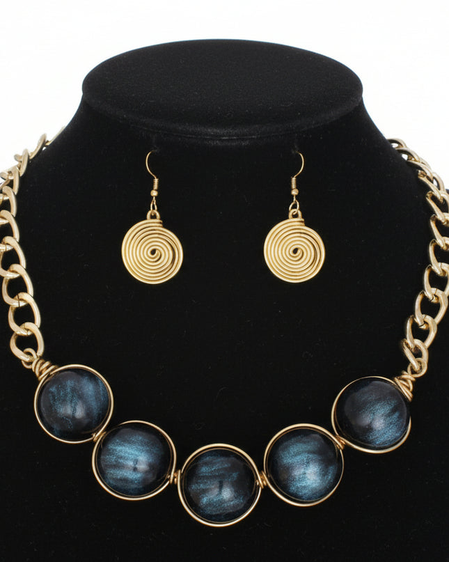 Women's Collar Necklace Set. Glossy and Galactic Chunky Gold Metal Chain Necklace with Eye-catching Centerpiece Collar Comprised of Jumbo Black Resin Ball Beads Featuring Swirled Blue Glitter Inlay and Hand-wrapped Gold Metal Wire Detail. 