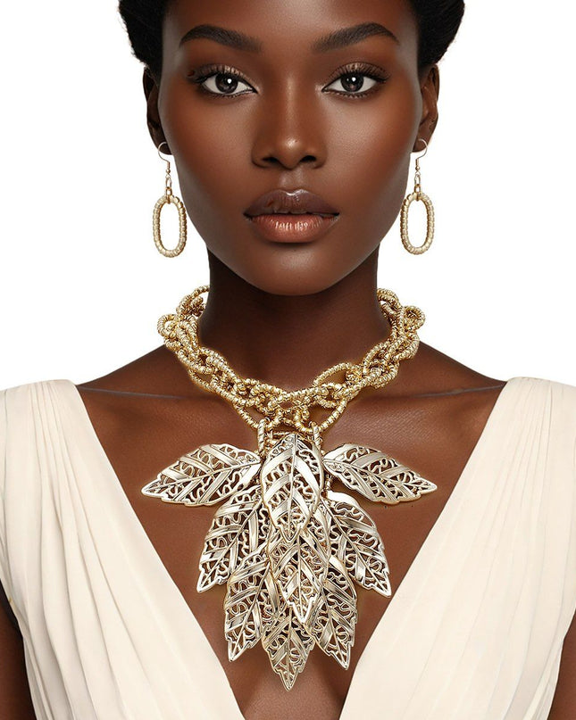Women's Bib Necklace Set. Autumn-inspired Fall Seasonal Statement Necklace. Chunky Lightweight Gold Metal Twist Design Oval Double Link Chain Necklace Featuring Bib Comprised of High-Shine Polished Gold Acrylic Layered Filigree Leaf Drop Details. 