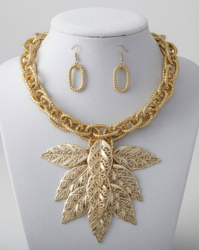 Women's Bib Necklace Set. Autumn-inspired Fall Seasonal Statement Necklace. Chunky Lightweight Gold Metal Twist Design Oval Double Link Chain Necklace Featuring Bib Comprised of High-Shine Polished Gold Acrylic Layered Filigree Leaf Drop Details. 