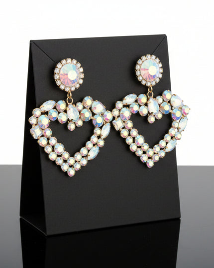 Each piece features a multi‑AURBO crystal heart, radiating a prism-like shimmer that shifts beautifully with movement. The stones sit in a sleek gold metal frame, creating a balance of softness and structure that feels both romantic and modern.