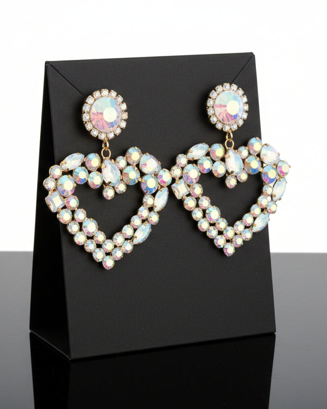 Each piece features a multi‑AURBO crystal heart, radiating a prism-like shimmer that shifts beautifully with movement. The stones sit in a sleek gold metal frame, creating a balance of softness and structure that feels both romantic and modern.
