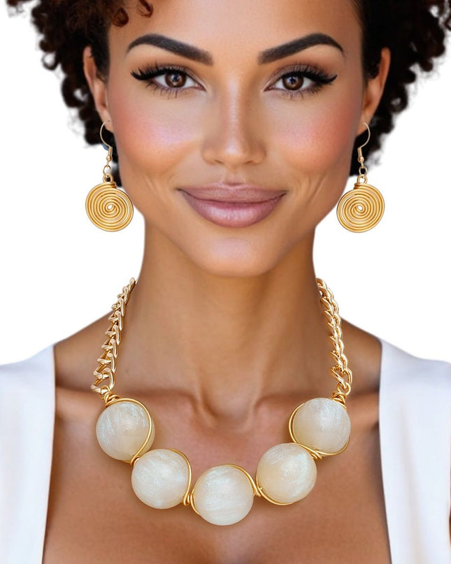 Women's Collar Necklace Set. Glossy and Galactic Chunky Gold Metal Chain Necklace with Eye-catching Centerpiece Collar Comprised of Jumbo Ivory Resin Ball Beads Featuring Swirled Glitter Inlay and Hand-wrapped Gold Metal Wire Detail. 