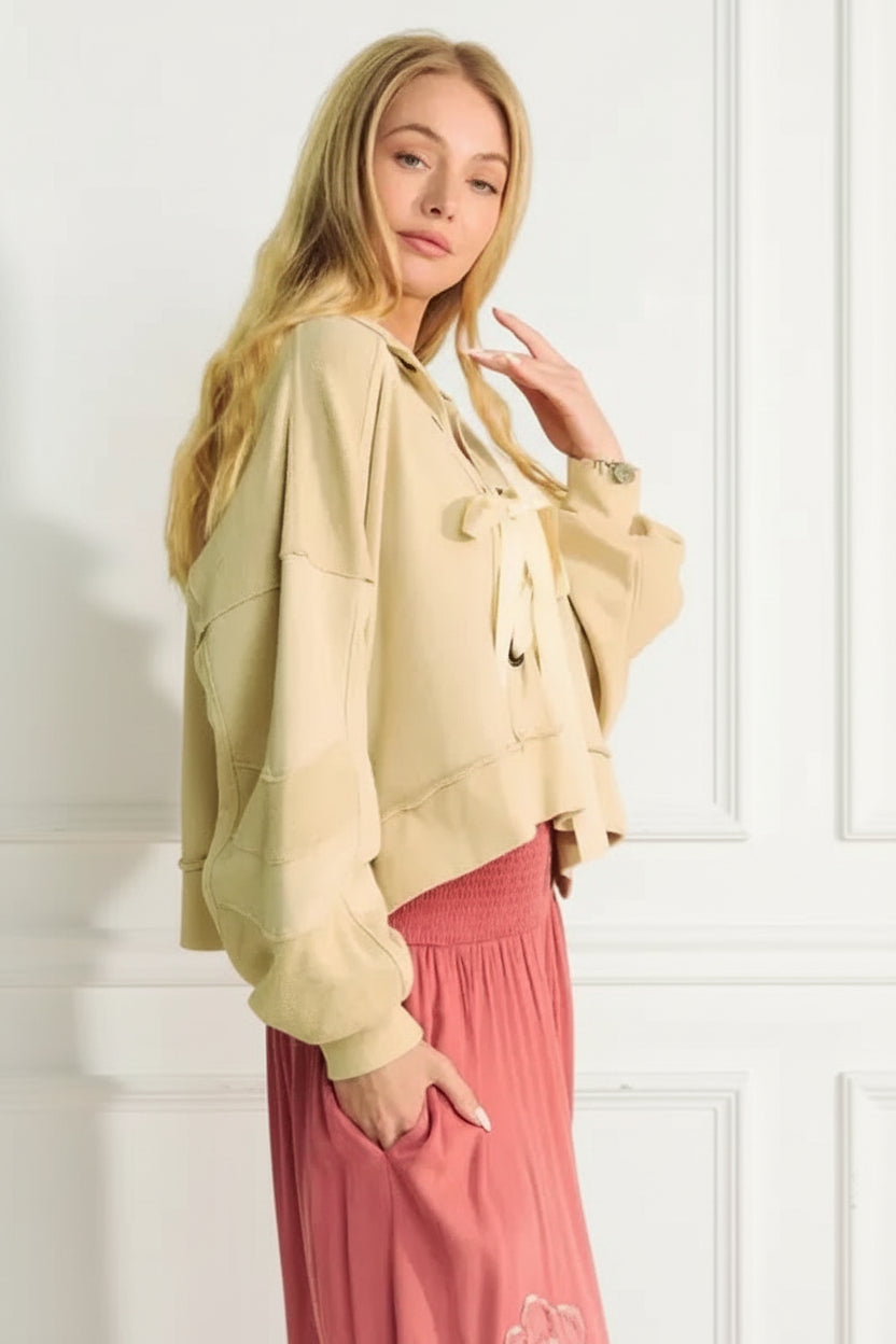 A lace-up exposed seam French terry top is a trendy and versatile garment that features a lace-up detail and visible seams. 