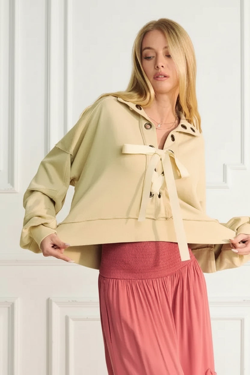 A lace-up exposed seam French terry top is a trendy and versatile garment that features a lace-up detail and visible seams. 