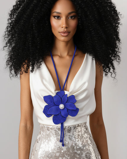 Person wearing a blue flower-shaped pendant necklace 