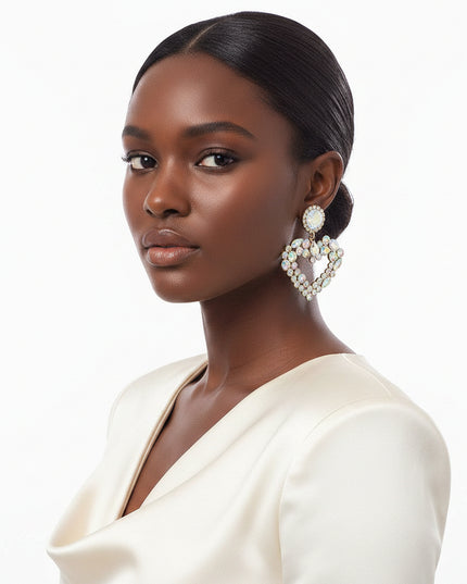 Each piece features a multi‑AURBO crystal heart, radiating a prism-like shimmer that shifts beautifully with movement. The stones sit in a sleek gold metal frame, creating a balance of softness and structure that feels both romantic and modern.