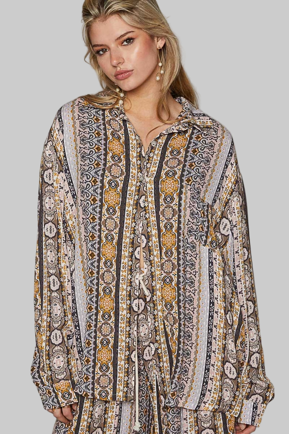 The Long Sleeve Button Down Printed Shirt is a versatile and trendy piece that adds a pop of personality to your wardrobe. Pair it with jeans for a casual daytime look.