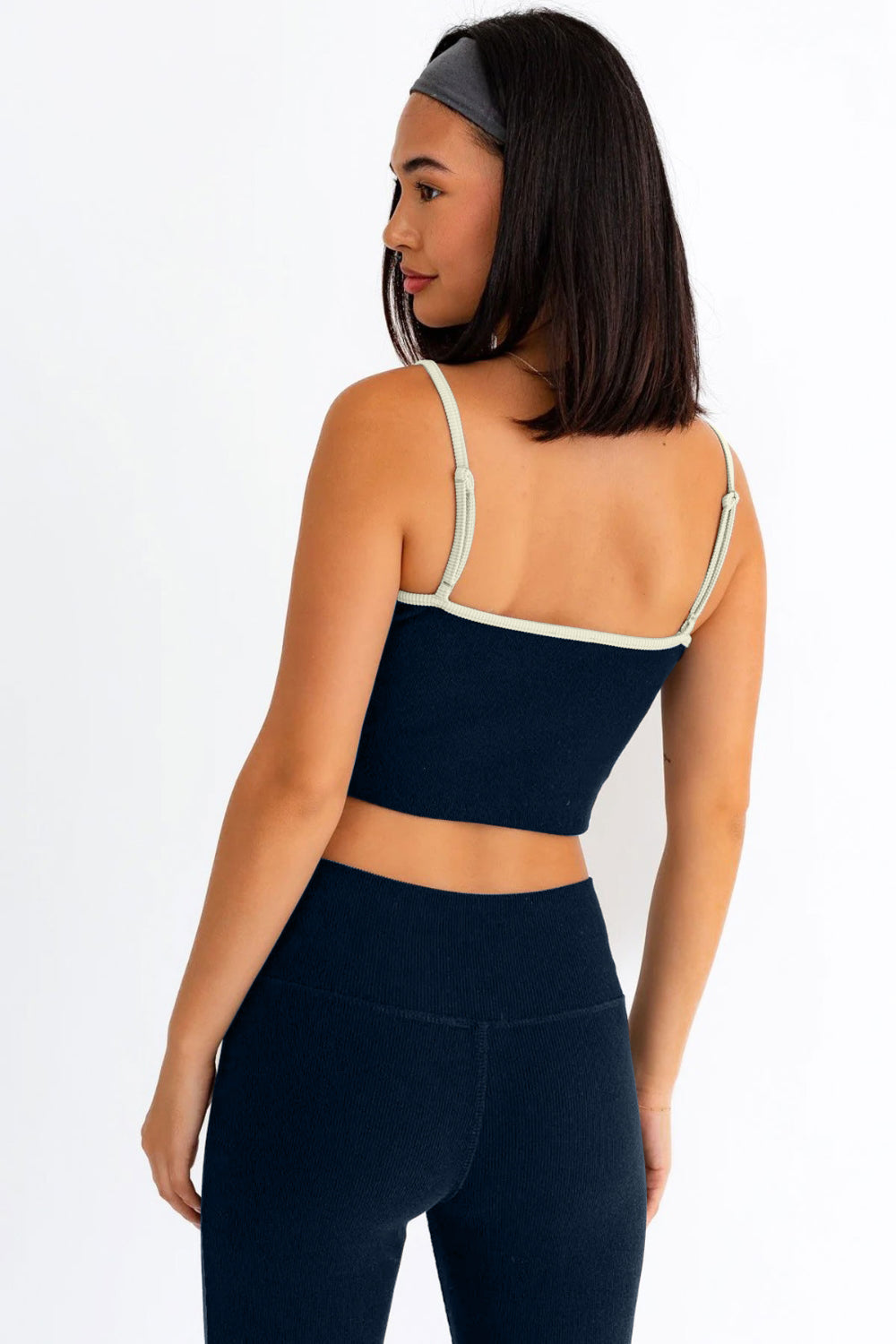 The Ribbed Crop Cami and High Waist Brushed Leggings set features a stylish design with contrast binding and spaghetti straps on the crop Cami top. The ribbed texture adds a trendy touch to the ensemble, making it ideal for activewear. The crop length Cami and high waist brushed leggings provide a snug and comfortable fit, perfect for workouts or yoga sessions. The stretchy and cool fabric ensures flexibility and breathability, making it the perfect attire for a workout or a comfy yet chic yoga look. 