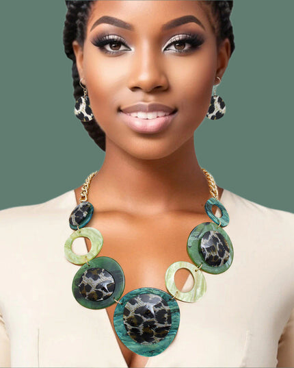 Women's Link Necklace Set Trending Marbled Shades of Green Acrylic with Glitter Linked Collar Design Featuring Rounded Leopard Print Acrylic Discs Details. Center Disc measures 2.75". Gold Metal Chain Lobster Clasp Closure. Includes Matching Fishhook Earrings.