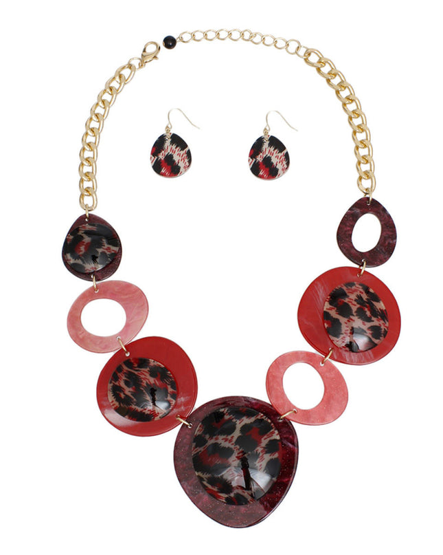 Women's Link Necklace Set Trending Marbled Shades of Red Acrylic with Glitter Linked Collar Design Featuring Rounded Leopard Print Acrylic Discs Details. Center Disc measures 2.75". Gold Metal Chain Lobster Clasp Closure. Includes Matching Fishhook Earrings.