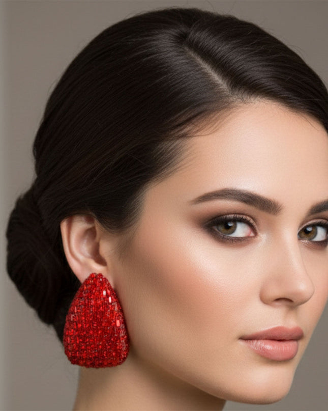 Women's Stud Earrings. Maximum Sparkle Statement Earrings. Bold Gold Metal Oversized Domed Teardrop Shaped Earrings Featuring Concave Center and Encrusted with Shimmering Red Baguette Crystals and Rhinestones.