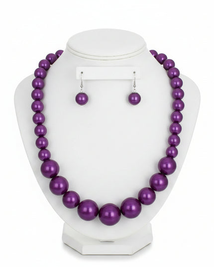 Women's Pearl Necklace Set. Single Strand Purple Acrylic Pearl Graduated Necklace. Neckline Pearls Measures 15.5 mm. Center Pearls Measure 30 mm. Chunky Bubblegum Pearls. Silver Metal Lobster Clasp Closure. Includes Matching Fish Hook Double Pearl Drop Earrings.