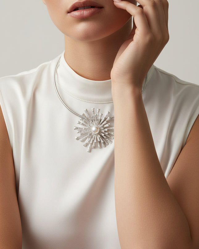 Silver necklace with a sunburst design and pearl center 