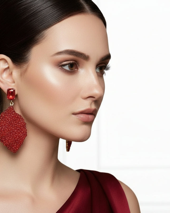 Women's Drop Earrings. Big Sparkle Energy Statement Earrings. Red Radiant Crystal Set in Gold Metal Stud Earrings Featuring Drop Natural Leaf Shaped Detail Encrusted with Sparkling Red Rhinestones.