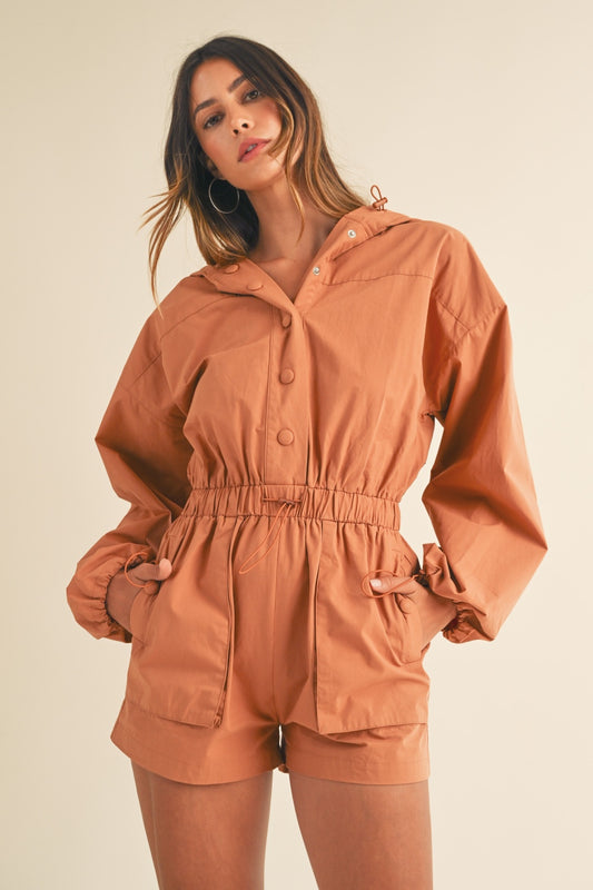 The Snap Down Long Sleeve Hooded Romper is a versatile and comfortable piece that is both stylish and practical. The long sleeves and snap-down detail add a trendy touch to this romper. The front snap detail on the hoodie gives it a modern flair. The elastic waistband detail ensures a flattering fit and adds to the overall comfort of the romper. Perfect for casual days or lounging at home, this romper combines fashion and functionality effortlessly. Stay cozy and chic with this must-have romper that offers 