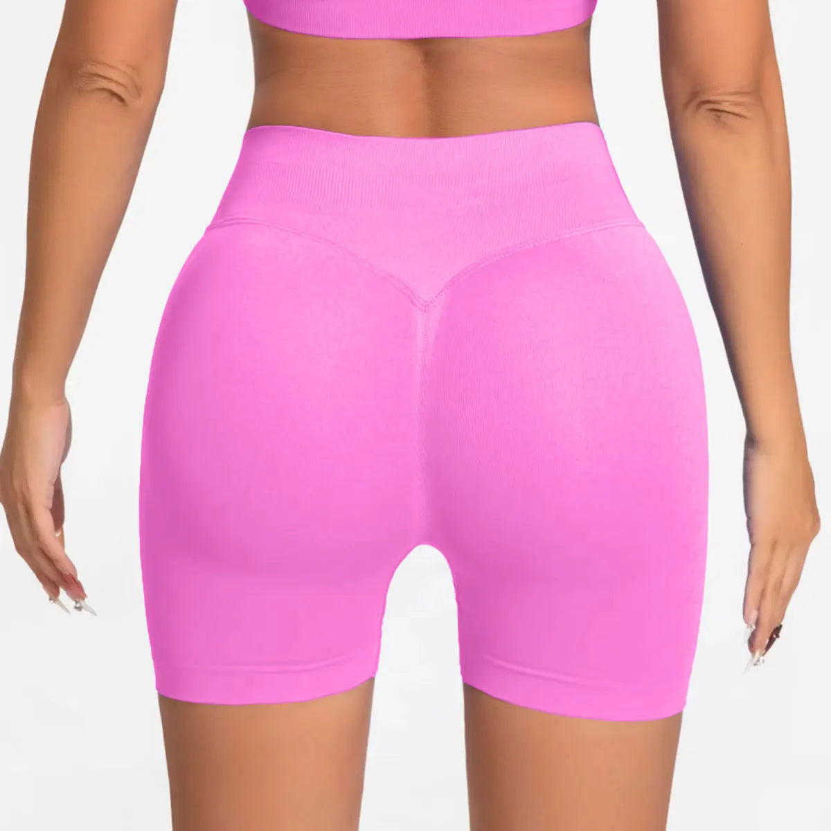 She's wearing pink high-waisted seamless 4.5" gym shorts and a black top.