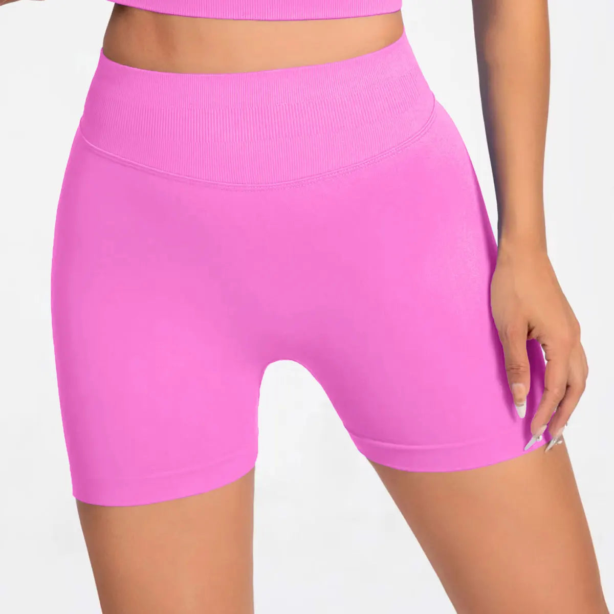 She's wearing pink high-waisted seamless 4.5" gym shorts and a black top.