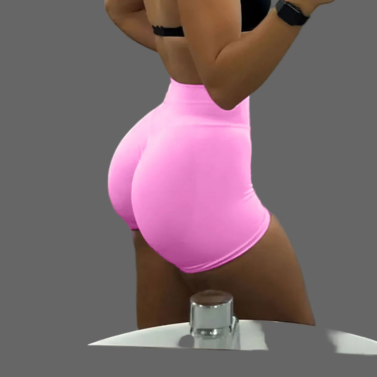 She's wearing pink high-waisted shorts and a black top 