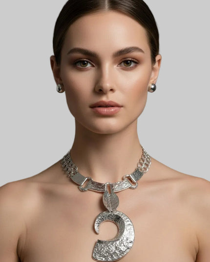 Women's Pendant Necklace Set. Edgy Oversized Chunky Silhouette Pendant Collar Necklace Featuring Hammered Silver Melted Metal Texture Linked Plate Collar with Large Dimensional Open C Chunky Pendant Suspended from Two Double Link Chains. Plate Collar Measures .75 inches Wide. Pendant Measures 4.75 inches x 2.75 inches. Lobster Clasp Closure. Includes Domed Post Backing Stud Earrings.