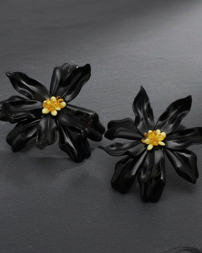 Women's Stud Earrings. Floral Statement Oversized Stud Earrings Featuring Large Dimensional Wavy Acrylic Petals in Bold Black with an Orange and Yellow Beaded Center. Bold and Eye-Catching Floral Playful Elegance. Earrings Measure 4.25 inches and 2.25 inches Tall. Post Backing.