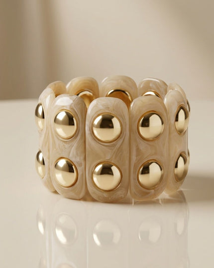 Women's Stretch Cuff Bracelet. Vintage-Style Artistic Marbled Beige Resin Long Oval Disc Stretch Bracelet Featuring Round Gold Stud Detailing. Bracelet Measures 2 inches wide. Neutral Natural Beauties Perfect for Stacking and Layering!