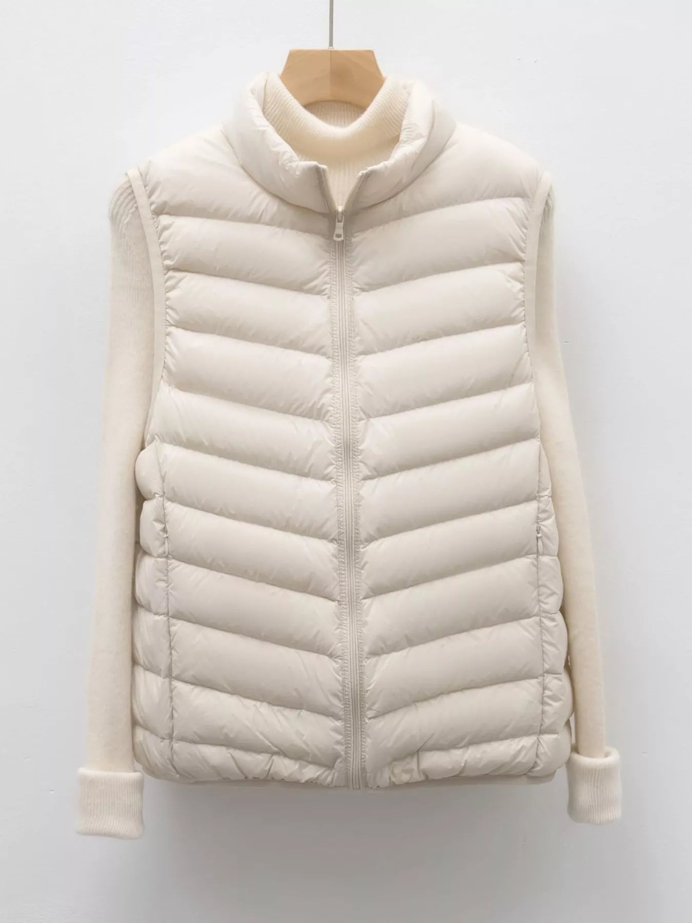 Ivory  puffer jacket on a wooden hanger