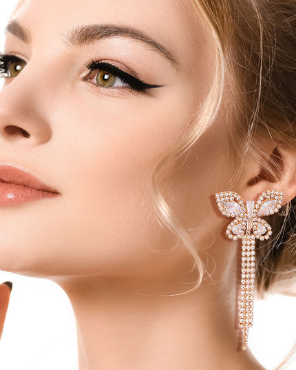 Gold Metal Butterfly Stud Earrings Featuring Rhinestone and Drop Fringe Detailing. Earrings measure 1.25 inches wide