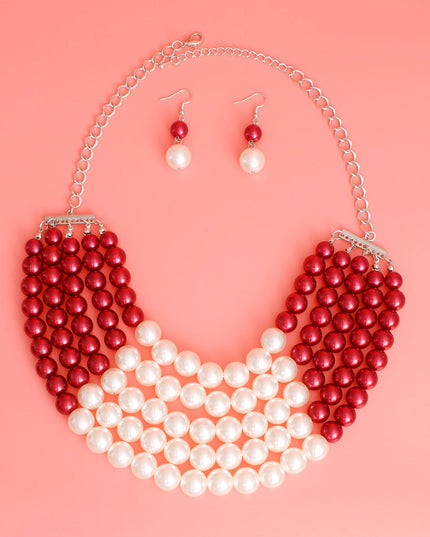  Featuring five cascading layers of lustrous cream pearls beautifully contrasted with bold red accents, this piece radiates sophistication and grace. The multi-strand design adds depth and drama, making it the perfect accessory for weddings or formal events