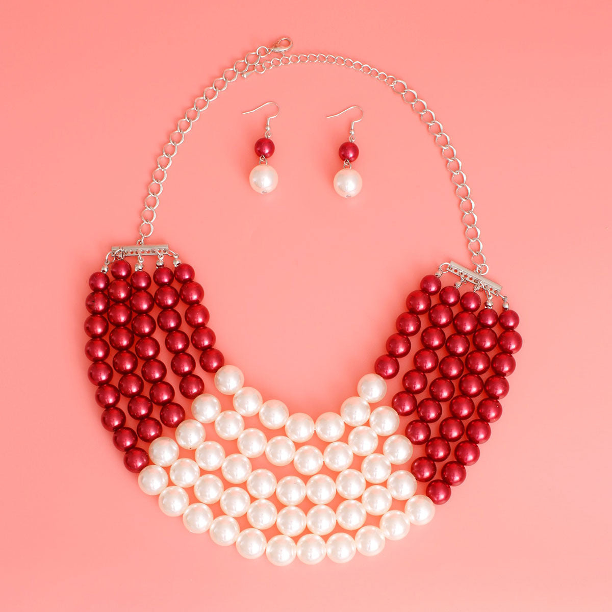  Featuring five cascading layers of lustrous cream pearls beautifully contrasted with bold red accents, this piece radiates sophistication and grace. The multi-strand design adds depth and drama, making it the perfect accessory for weddings or formal events
