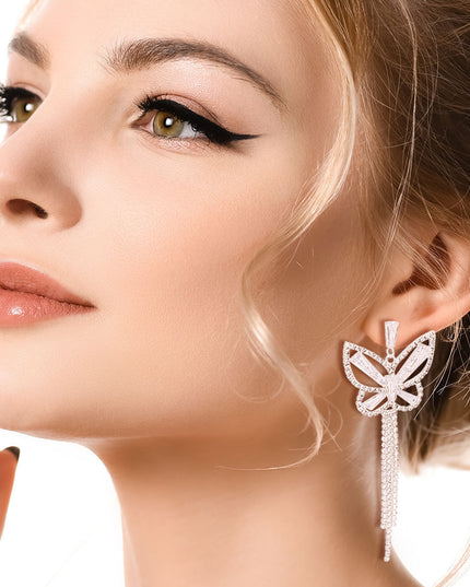 Silver Metal Butterfly Stud Earrings Featuring Rhinestone and Drop Fringe Detailing. Earrings measure 1.25 inches wide